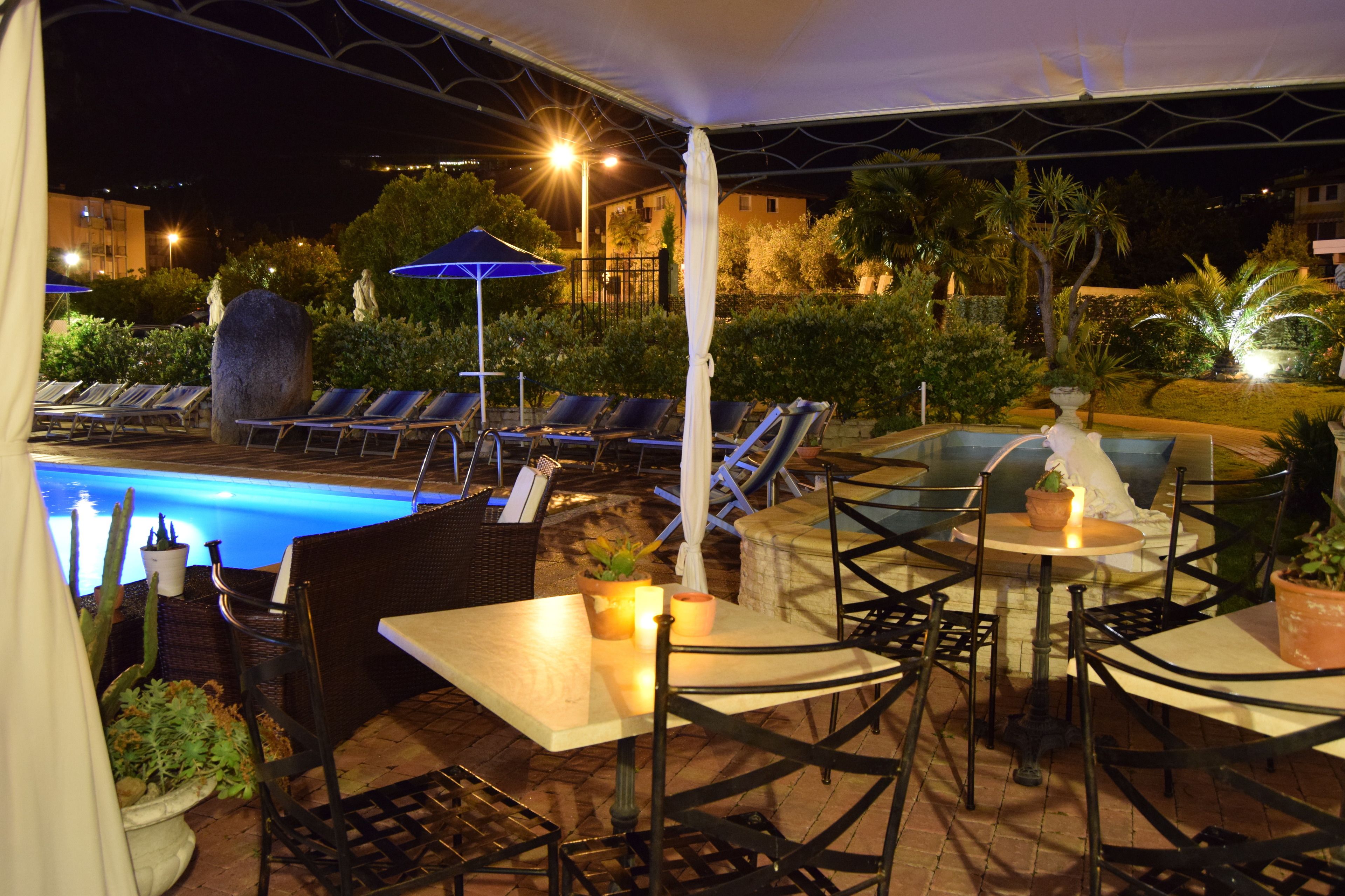 A poolside area with lounge chairs, tables, and umbrellas.