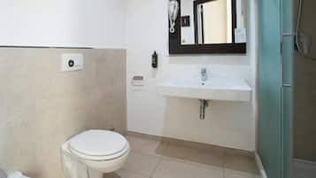 A bathroom with a toilet, sink, and shower.