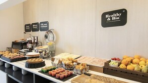 Un bufé con diversos alimentos, incluyendo pasteles, pan y frutas.