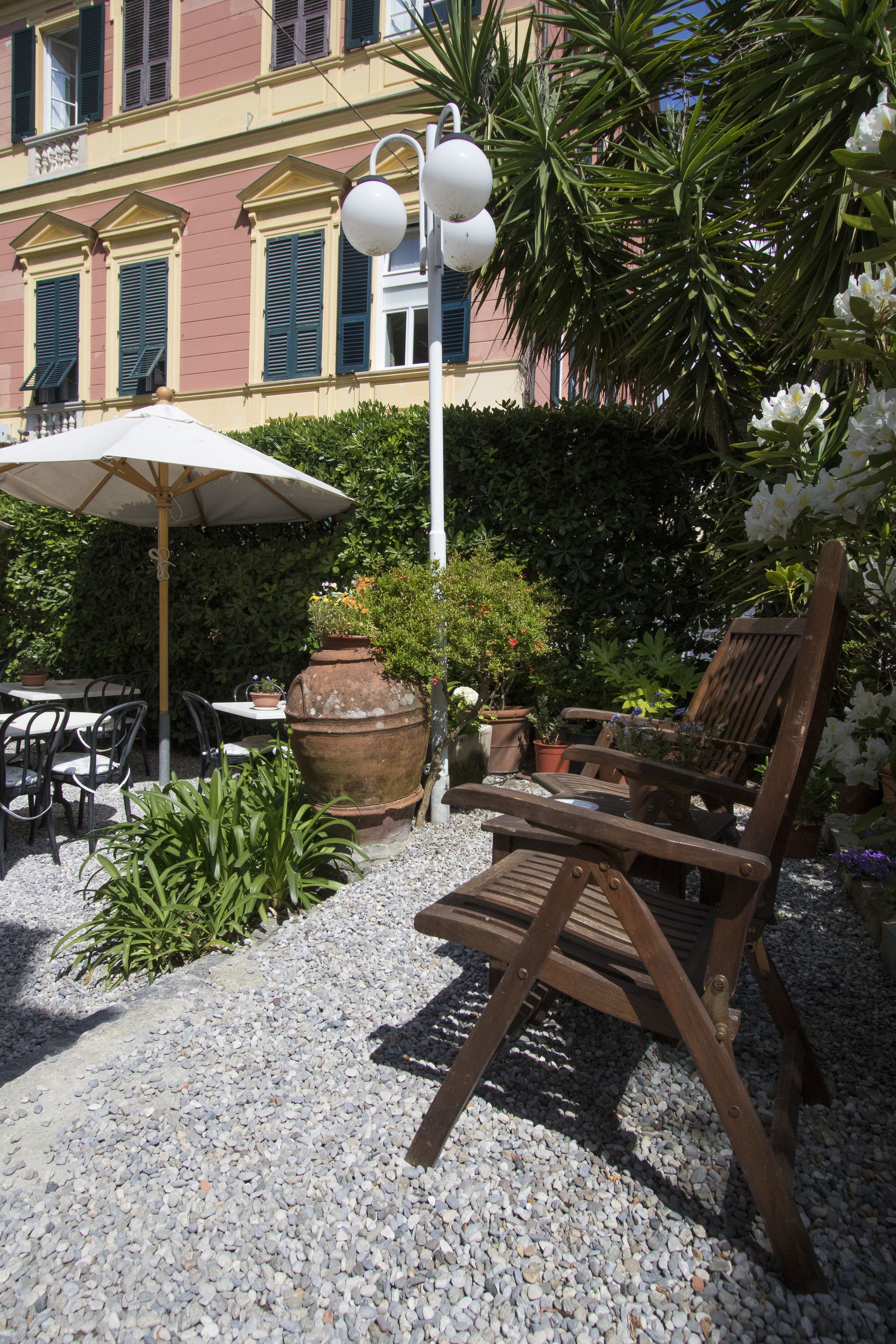 An outdoor seating area with tables, chairs, and a large umbrella.