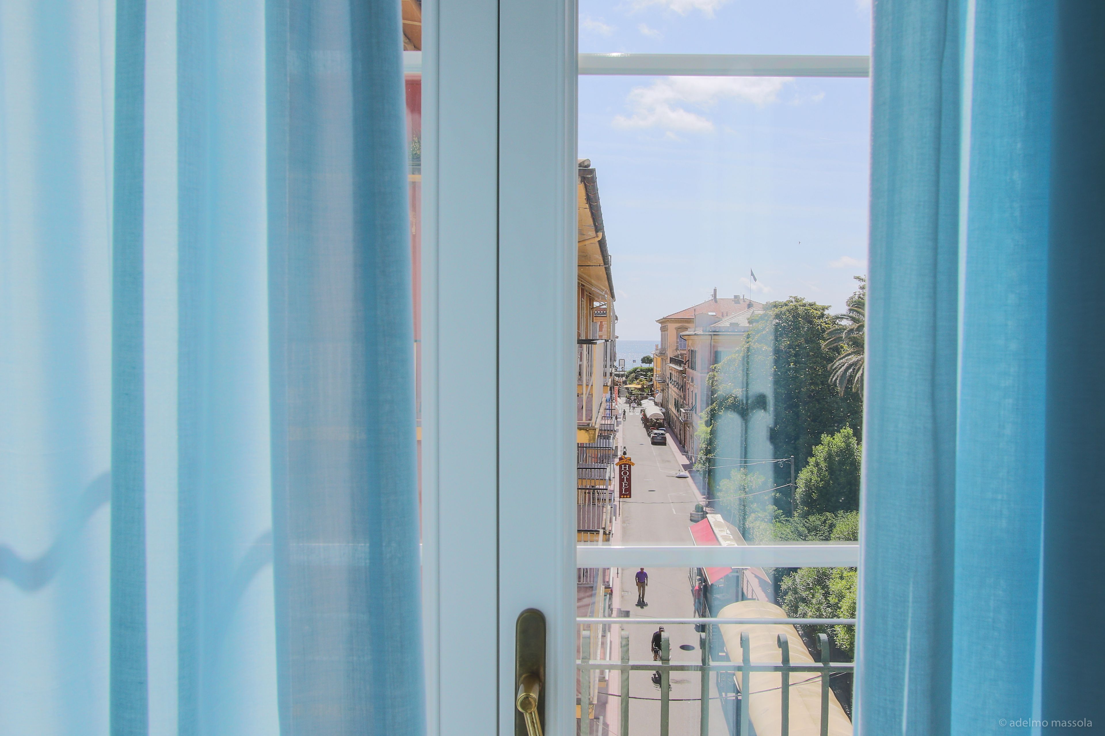 A view from a balcony with a clear sky and buildings in the distance.
