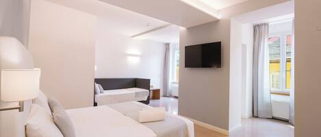 Une chambre d’hôtel moderne avec deux lits, un téléviseur à écran plat et une vue sur l’extérieur.