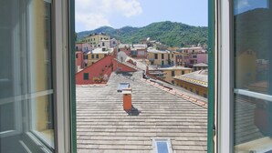 A view from a window overlooking a town with buildings and a hill in the background. - Hotel Nazionale (Levanto)