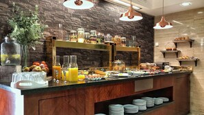 Un buffet proposant une variété de plats, des récipients en verre et un assortiment de boissons.