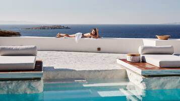 Een buitenzwembad, parasols voor strand/zwembad