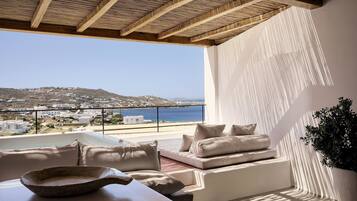 Una sala de estar moderna con vista al mar y un balcón.