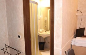 Un bagno con lavandino, specchio e porta asciugamani.
