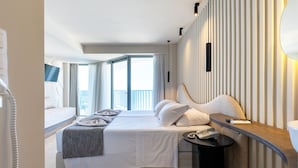 Una habitación de hotel con cama, mesita de noche y vistas al balcón.