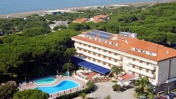Un hotel con piscina, immerso nel verde e vista mare.