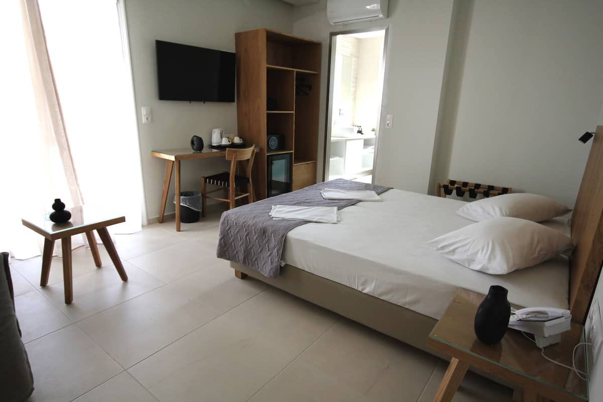 Une chambre d’hôtel comprenant un lit, un bureau, une chaise, une armoire et un téléviseur.