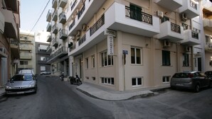 A hotel with a sign indicating it is a "HOTEL MARABELLO" located on a narrow street with parked cars and a motorcycle. - Mirabello Hotel (Heraklion)