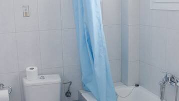 Een badkamer met toilet, bidet en bad.