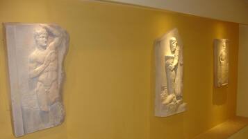 A hallway with three stone sculptures on the wall.