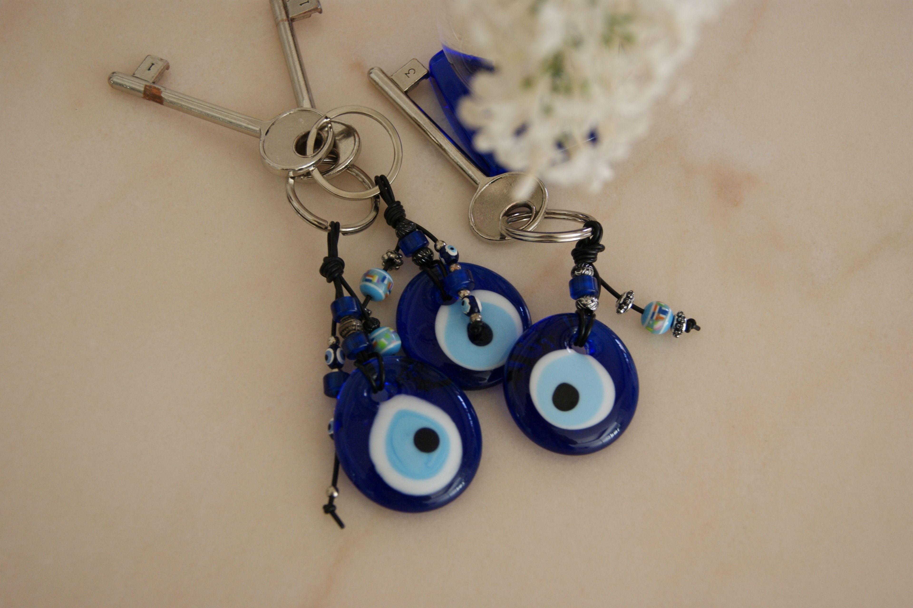 A set of keychains with blue and white designs, including a key and a key ring.
