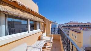 A balcony with white furniture, a view of the city, and a clear blue sky. - Hotel Madrid (Torrevieja)