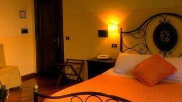 Une chambre d’hôtel avec un lit, une table de chevet, une chaise et une porte.