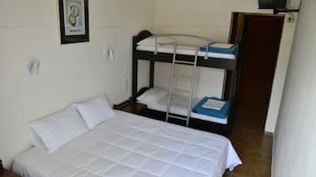 A bunk bed with a ladder, a single bed, and a television on a shelf.