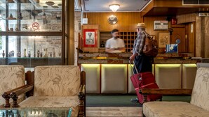 A lobby with a reception desk, seating area, and a display of artifacts. - Acropolis View Hotel (Athens)