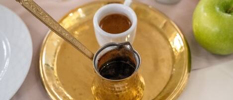 A tray with a small cup of coffee and a spoon.