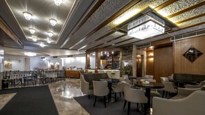 A spacious lobby with a bar area, seating arrangements, and a chandelier. - Acropolis View Hotel (Athens)