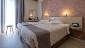 A modern hotel room with a large bed, bedside tables, a small stool, and a wall-mounted TV. - Acropolis View Hotel (Athens)
