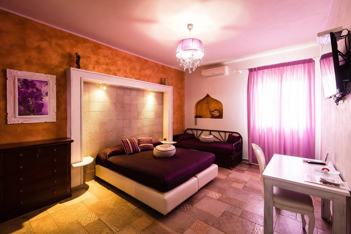 A bedroom with a bed, a dresser, a desk, and a chair.