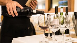 A person pouring wine into several glasses on a table. - Hotel Ristorante Cavalluccio Marino (Lampedusa)