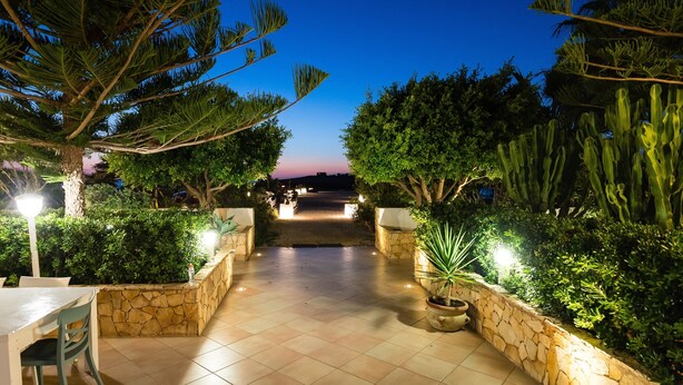 An outdoor pathway leading to a building, flanked by stone walls and various plants. - Hotel Ristorante Cavalluccio Marino (Lampedusa)