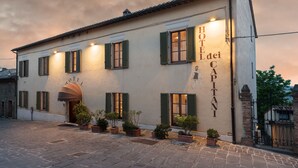 Un hotel amb una façana clàssica, diverses finestres amb persianes i un rètol que indica que és l'