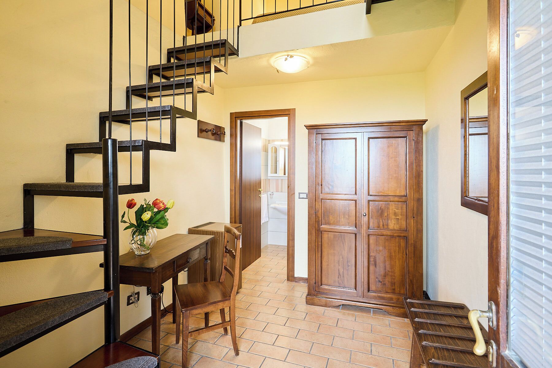Una escalera de diseño moderno, una puerta de madera y un piso con baldosas.