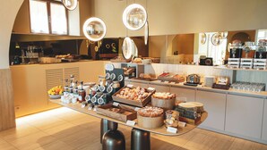 Dispositiu de buffet amb diversos plats, un espai per al cafè i un taulell de begudes.