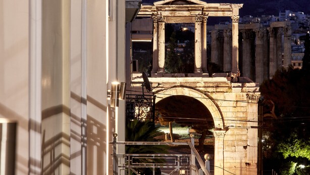 A classical structure with columns, possibly a historical monument, in an urban setting at night.