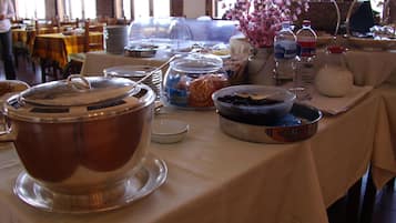Una mesa de desayuno buffet con varios recipientes de comida y utensilios.