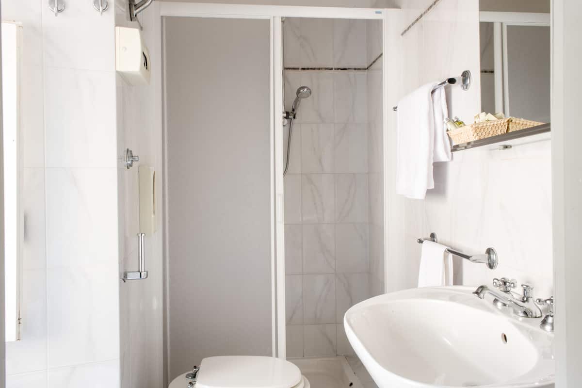 A bathroom with a shower, toilet, and sink.