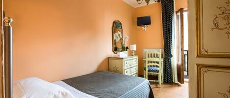 Un dormitorio con cama, cómoda, espejo y televisor en la pared.
