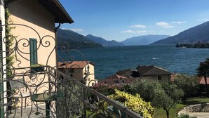 A balcony with wrought iron railings overlooking a lake with mountains in the background. - Crotto Regina (Gravedona)