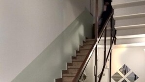 A staircase with wooden steps and a glass railing.