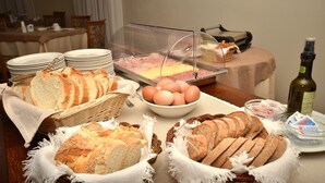Un bufé de desayuno con pan, huevos y una botella de aceite de oliva.