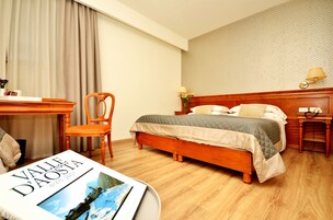 Minibar, escritorio, cortinas blackout y tabla de planchar con plancha 