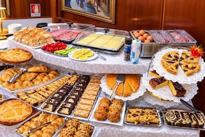 A buffet with various food items including pastries, pies, and sandwiches. - Hotel Fiorella Milano (Milan)