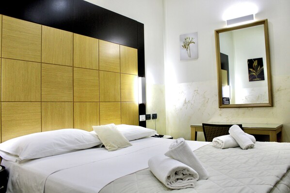 A hotel room with a bed, a desk, and a mirror. - Hotel Fiorella Milano (Milan)