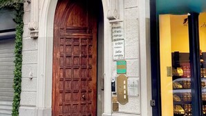 A hotel sign with a classic design and a wooden door. - Hotel Fiorella Milano (Milan)