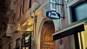 A hotel named "Hotel Fiorello" with a classic architectural style, featuring ornate balconies and a prominent neon sign. - Hotel Fiorella Milano (Milan)