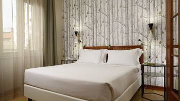 A neatly made bed with white linens in a hotel room.