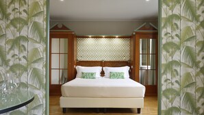 Ein Schlafzimmer mit einem großen Bett, einem Holzkopfende und einer Wand mit Muster.