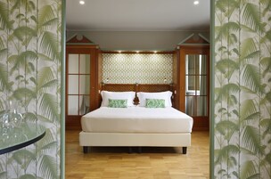 Camera da letto con un letto grande, una testiera in legno e carta da parati decorata.