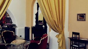 Una habitación con una cama, dos sillones, una mesita y una lámpara.