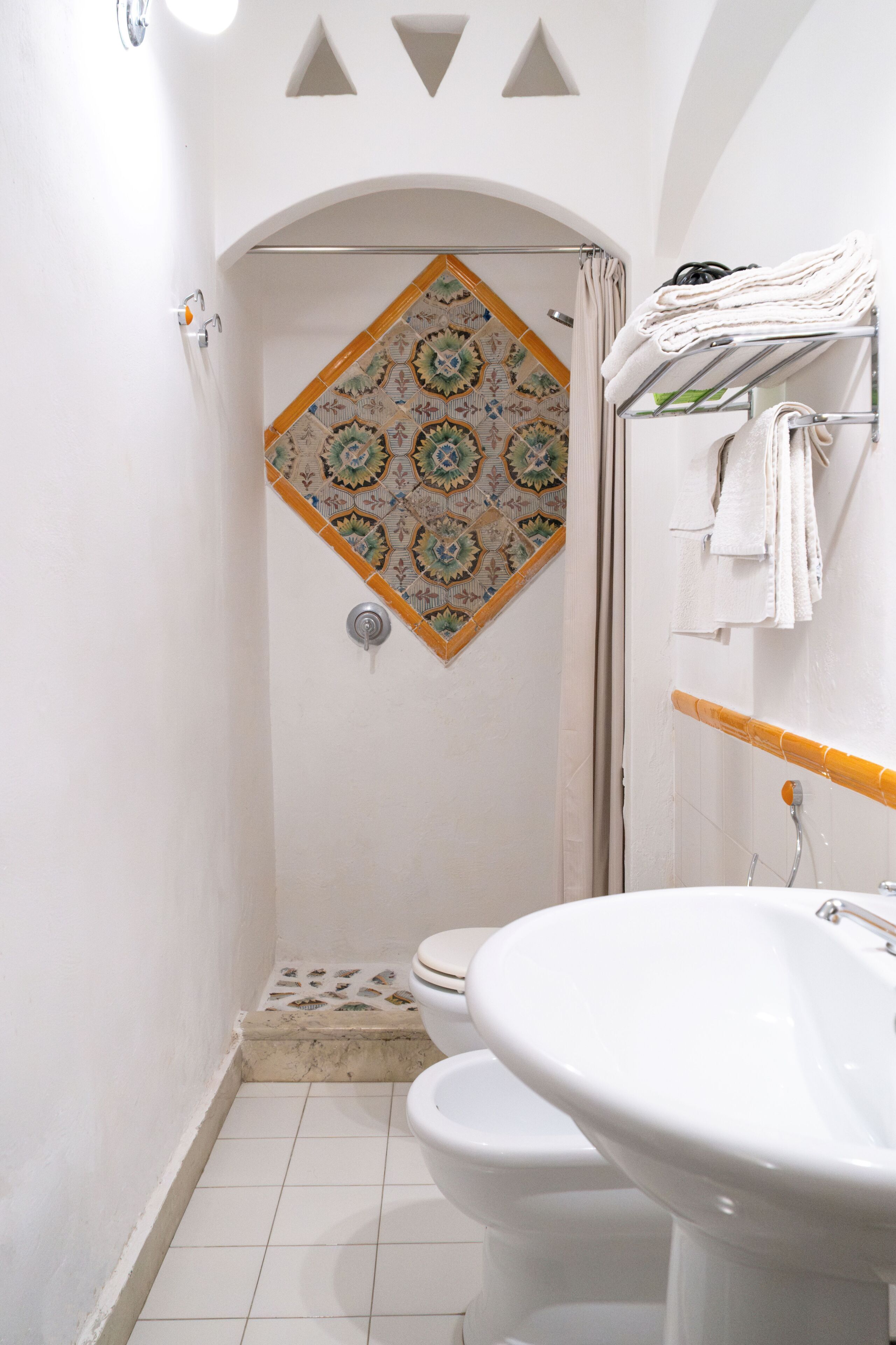 A bathroom with a shower, a toilet, and a sink.