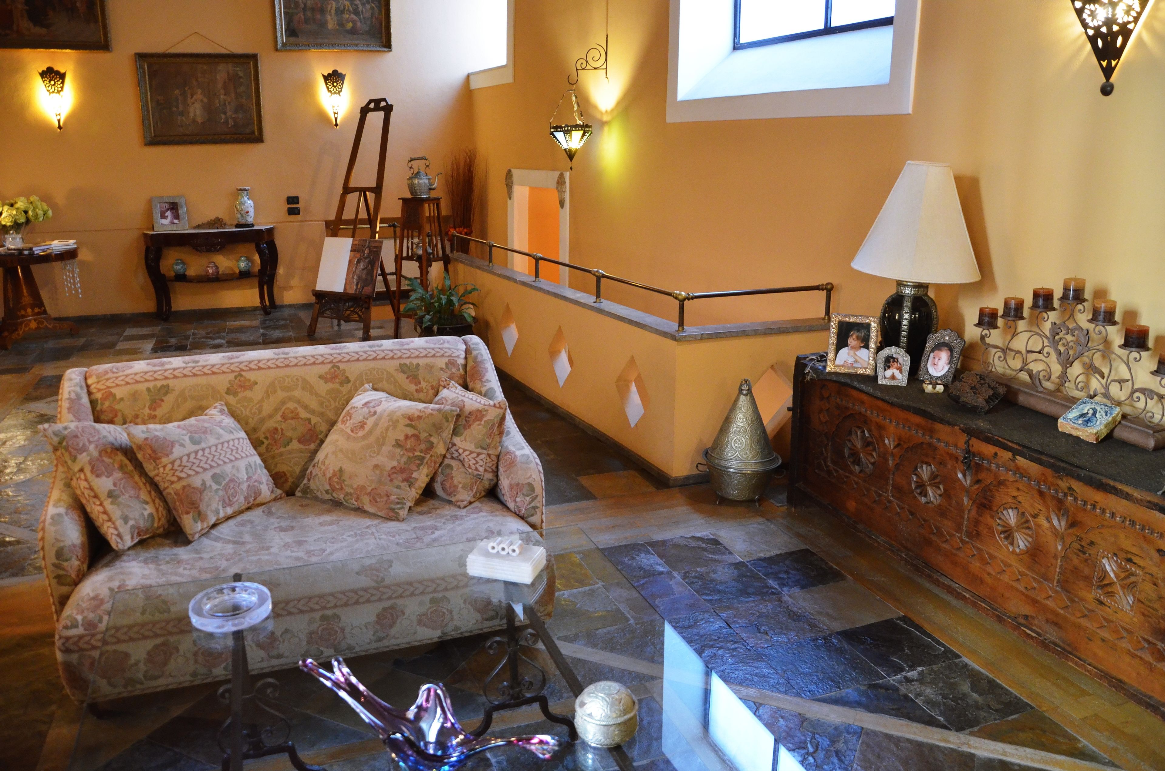 A cozy living room with a sofa, a small table, and a decorative lamp.