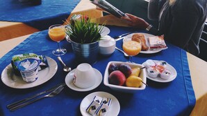 A breakfast table with a variety of food items, including a croissant, fruit, and juice. - Albergo della Corona (Binasco)